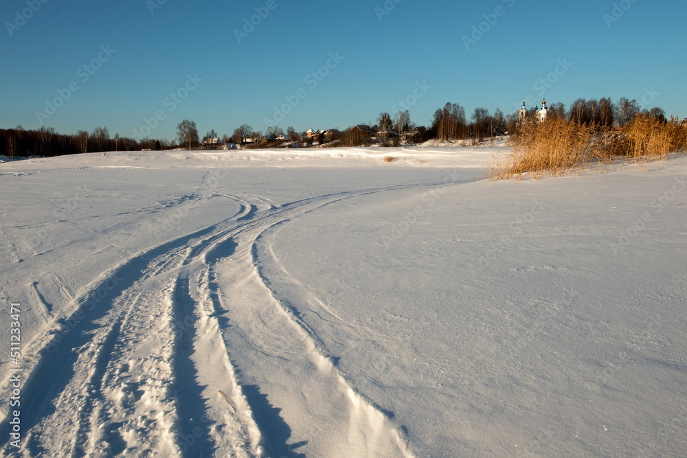 Traces of vehicles and people on the frozen and snow-covered Volga River