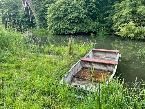 Old wooden rowing fishing boat on the shore of the pond in Lednice, Czech Republic. Typical rural nature of Czech Republic. High quality photo photo