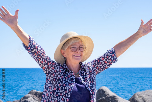 Happy smiling caucasian woman with straw hat and outstretched arms enjoying sea and freedom in vacation #511234881