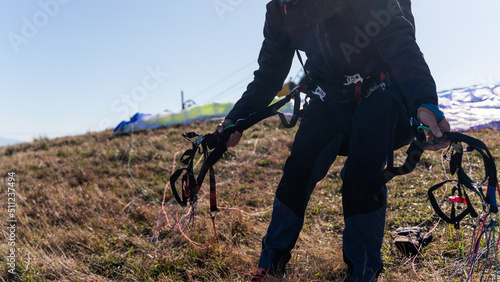 Unrecognizable paraglider is preparing for a flight.