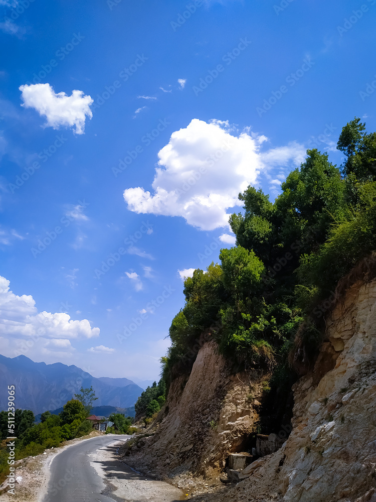 A amazing view of road to the mountains with blue sky and clouds