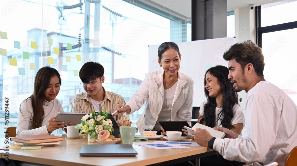 Mature business team leader talking, giving instructions to diverse staff at corporate meeting Mature business team leader talking, giving instructions to diverse staff at corporate meeting