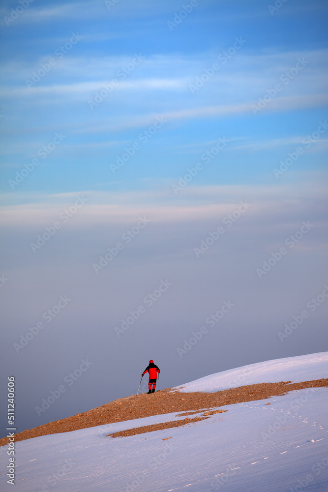 Hiker on edge of cliff in sunrise