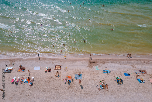 Rest on the seashore. Resort place. "Fedotov braid". located in Kyrylivka in southern Ukraine. View from above. Sea of ​​Azov. The family is relaxing on the beach. Girl, woman, man, boy © Denis Chubchenko