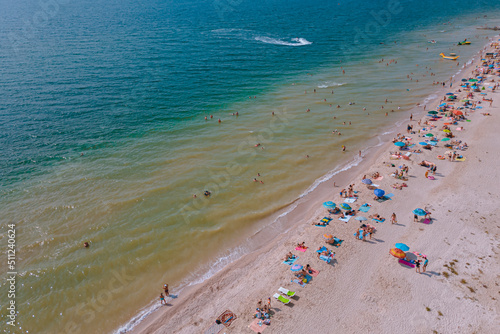 Rest on the seashore. Resort place. "Fedotov braid". located in Kyrylivka in southern Ukraine. View from above. Sea of ​​Azov. The family is relaxing on the beach. Girl, woman, man, boy © Denis Chubchenko