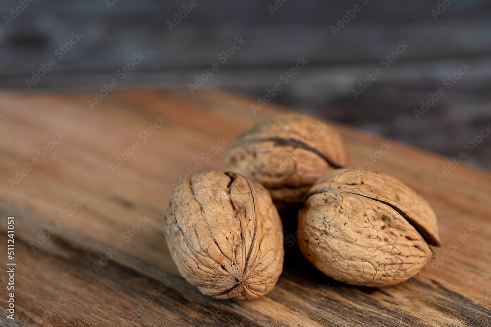 brown walnuts on wooden background brown walnuts on wooden background