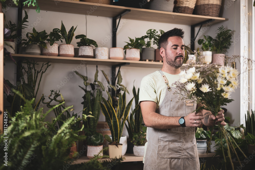 a florist man making a bouquet of flowers for an order.own business a florist man making a bouquet of flowers for an order.own business