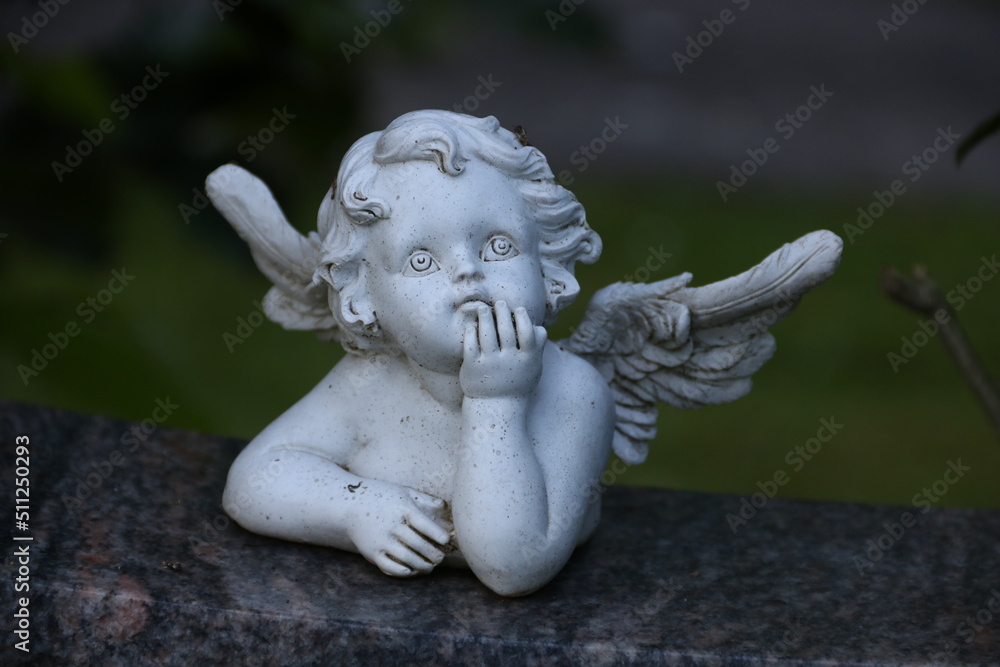 Kleiner Engel auf einem Grabstein auf dem Friedhof Kleiner Engel auf einem Grabstein auf dem Friedhof