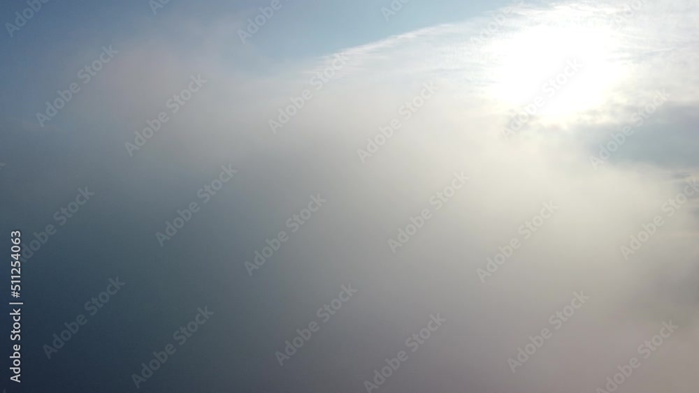 Aerial view. Blue sky sun and fog over calm sea. The drone flies over foggy and fluffy clouds. Abstract aerial nature summer ocean sunset sea and sky background. Vacation, travel and holiday concept. Aerial view. Blue sky sun and fog over calm sea. The drone flies over foggy and fluffy clouds. Abstract aerial nature summer ocean sunset sea and sky background. Vacation, travel and holiday concept.