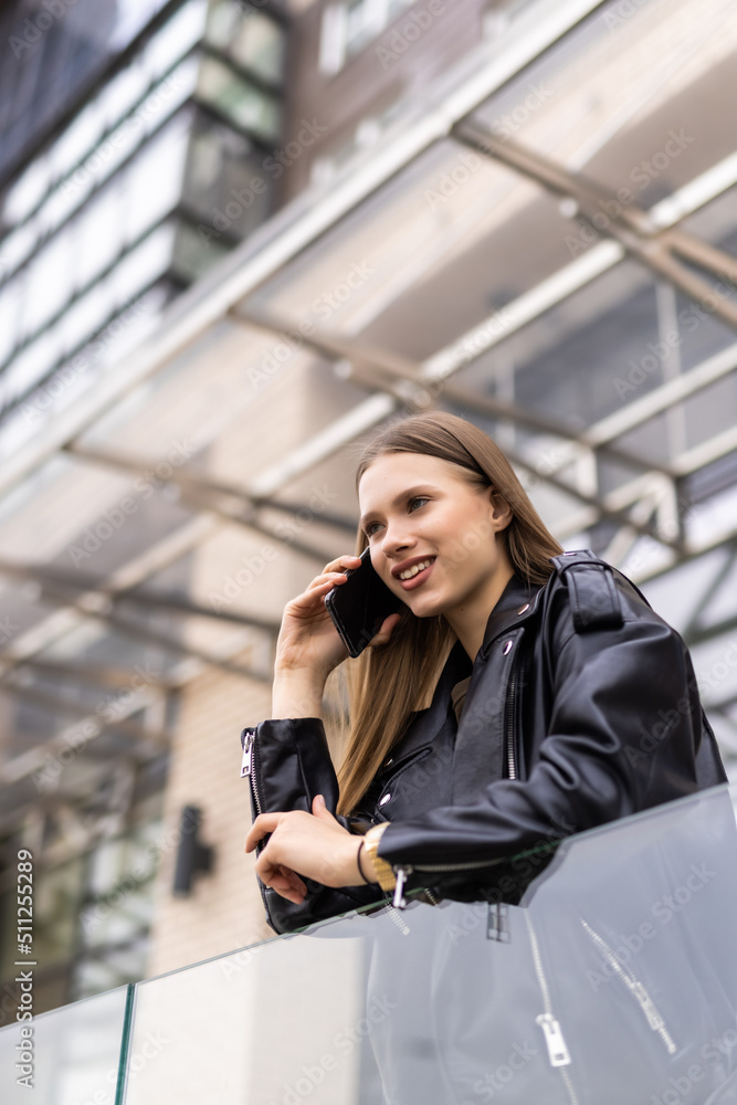 Young woman walking outdoors, talking on mobile phone Young woman walking outdoors, talking on mobile phone
