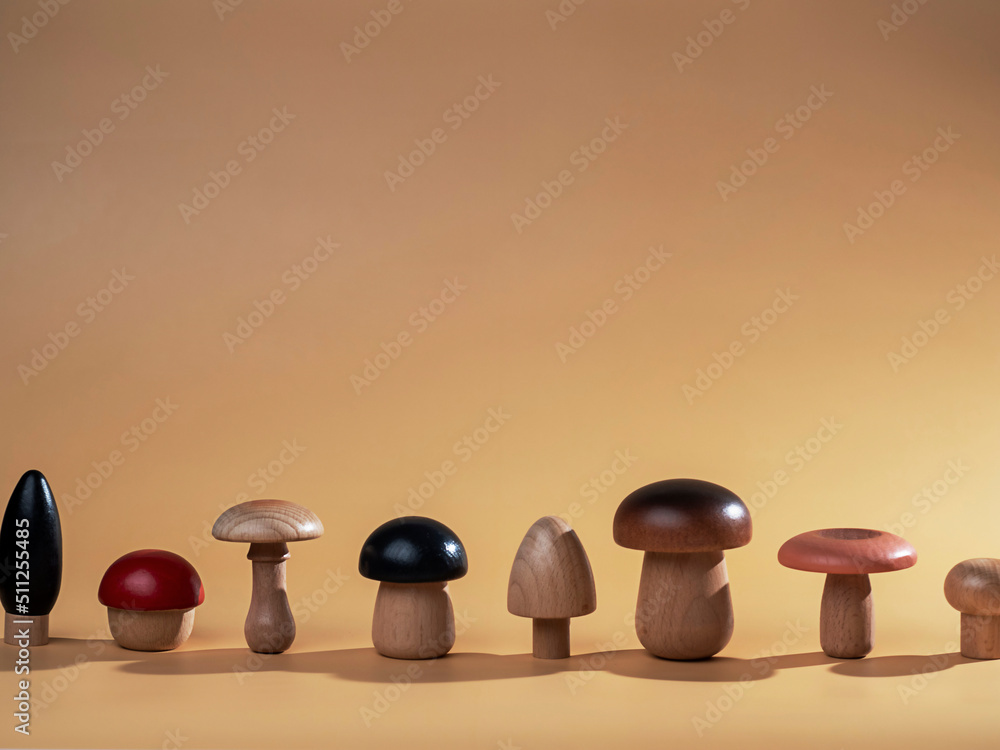 Wooden mushroom figures on beige background with space for text. Ecology concept, abstract background. Wooden mushroom figures on beige background with space for text. Ecology concept, abstract background.