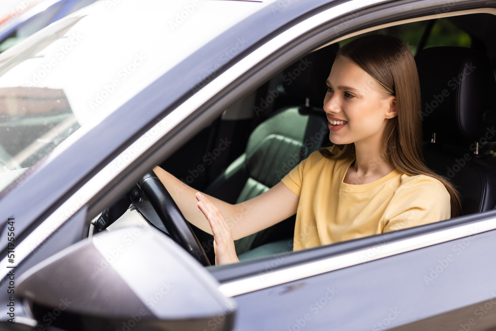 Young woman hand pressing the horn button while driving a car through the road. Young woman hand pressing the horn button while driving a car through the road.