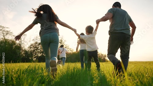 happy family running in the park in summer. mom and dad hold their son by the hands run throw up in the forest park on the grass in the summer. happy family kid lifestyle dream concept