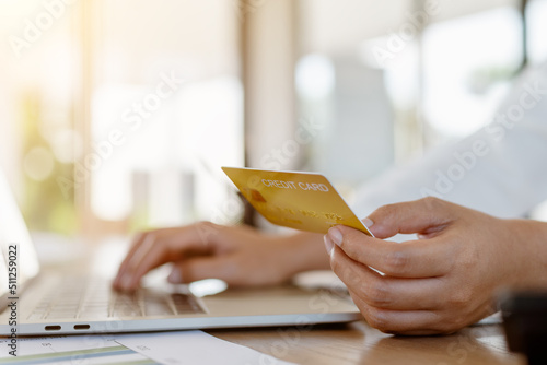 Close up business hands using laptop with mock up credit card for payment online.