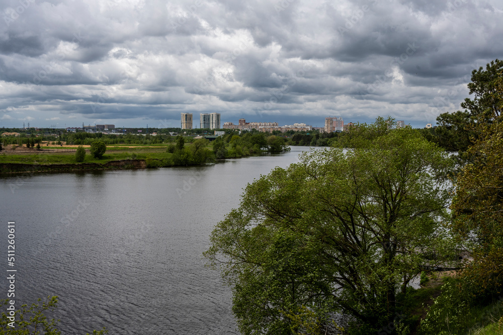 Fototapeta premium urban landscape on a summer day with river houses and woodlands