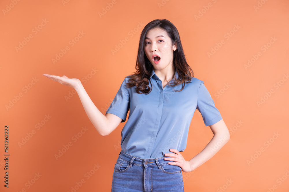 Young Asian business woman posing on orange background Young Asian business woman posing on orange background