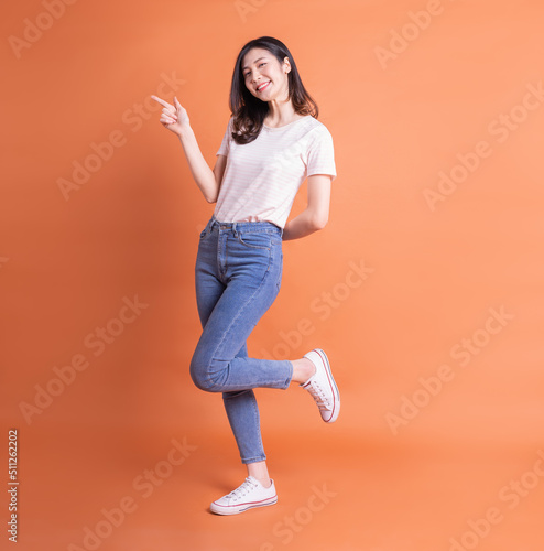 Foto Full length image of young Asian woman posing on orange background