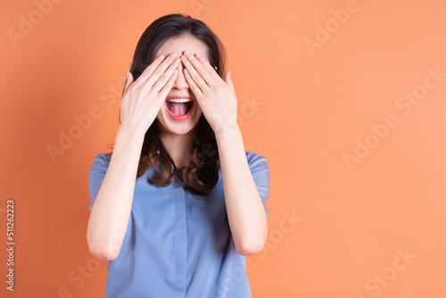 Young Asian business woman posing on orange background © Timeimage