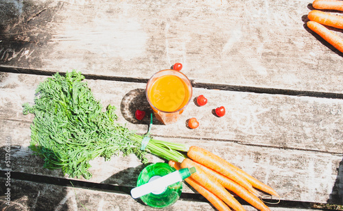 Carrots, bottle, and cherries on a wooden table, Healthy food concept.