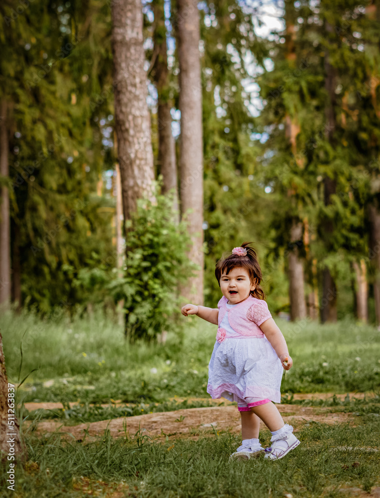 little 2 year old girl in a park near a forest little 2 year old girl in a park near a forest