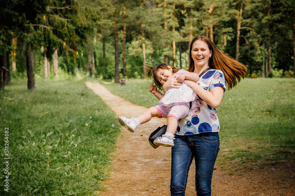 beautiful and young girl with her little girl for a walk playing in a park outdoors near a forest beautiful and young girl with her little girl for a walk playing in a park outdoors near a forest