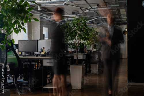 Blurred female figures in motion in the office.