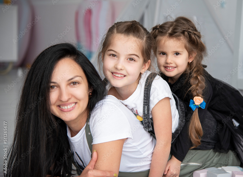 happy  beautiful mother with two little daughters smiling.  portrait of a family