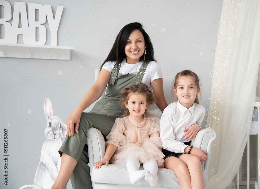 happy family mother and two daughters sitting on sofa