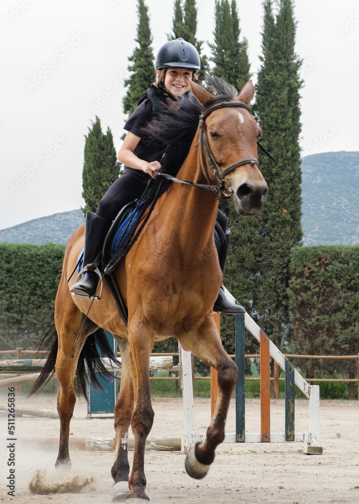 Young happy boy ridding horse during horseback lessons. Young happy boy ridding horse during horseback lessons.