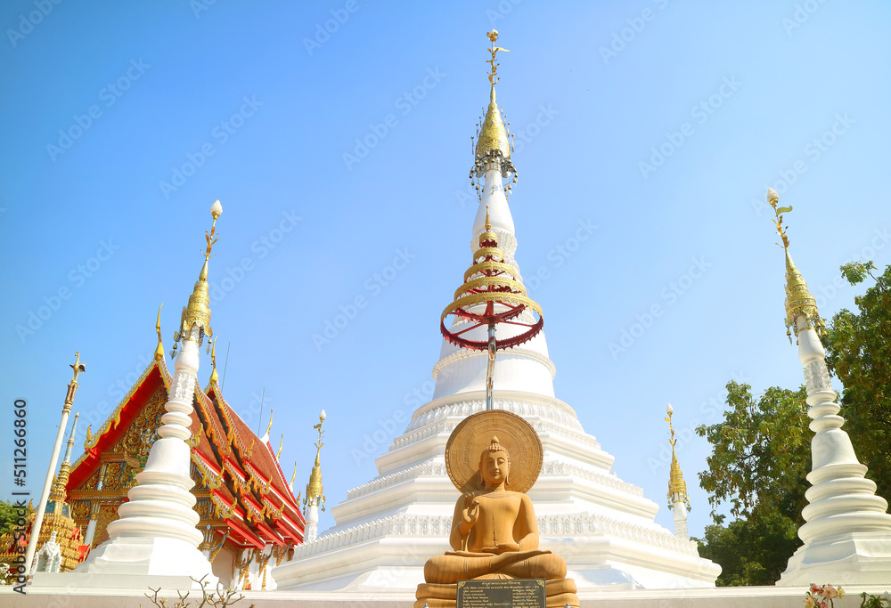 Fototapeta premium Beautiful Seated Buddha Image and Mantra at the Base with Group of Mon Style Pagoda in Backdrop, Wat Chomphuwek Buddhist Temple, Nonthaburi Province, Thailand