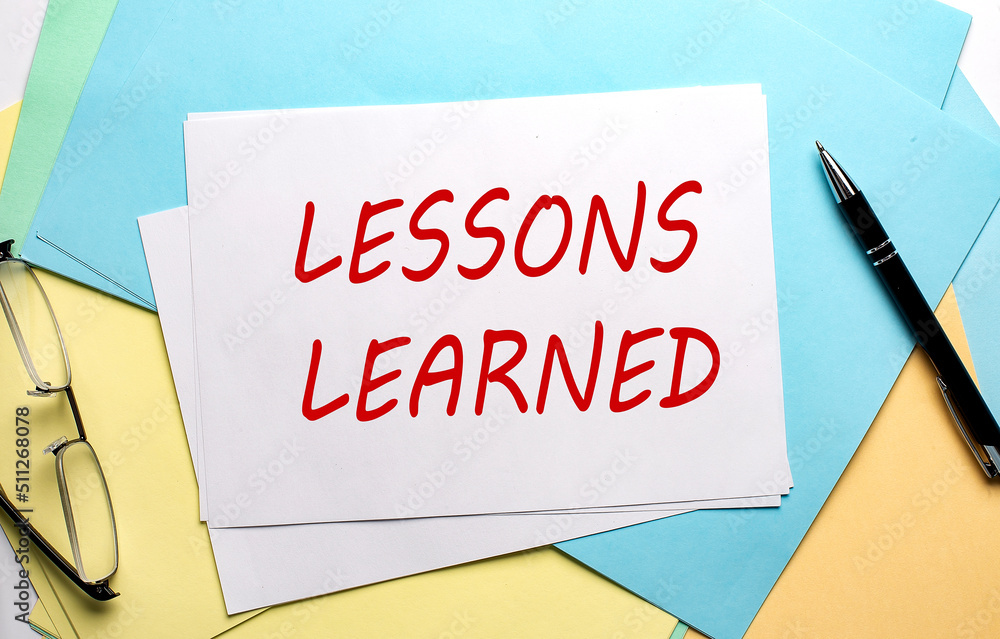 LESSONS LEARNED text on paper on the colorful paper background LESSONS LEARNED text on paper on the colorful paper background