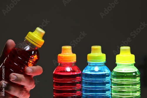 Hand holding a sports drinks, also known as electrolyte drinks, are functional beverages whose stated purpose is to help athletes replace water, electrolytes, and energy before, during sports activity photo