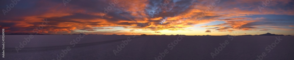 Large natural panorama of salar de Uyuni salt marsh in Bolivia at sunset. Amazing colorful view of setting sun late in evening in good weather. Concept of travel. Copy space for the site