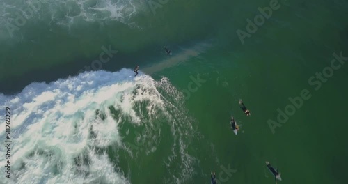 following surfer catching a wave off at Guincho Beach and doing some cutbacks in Cascais, Portugal. aerial view - drone shot. photo