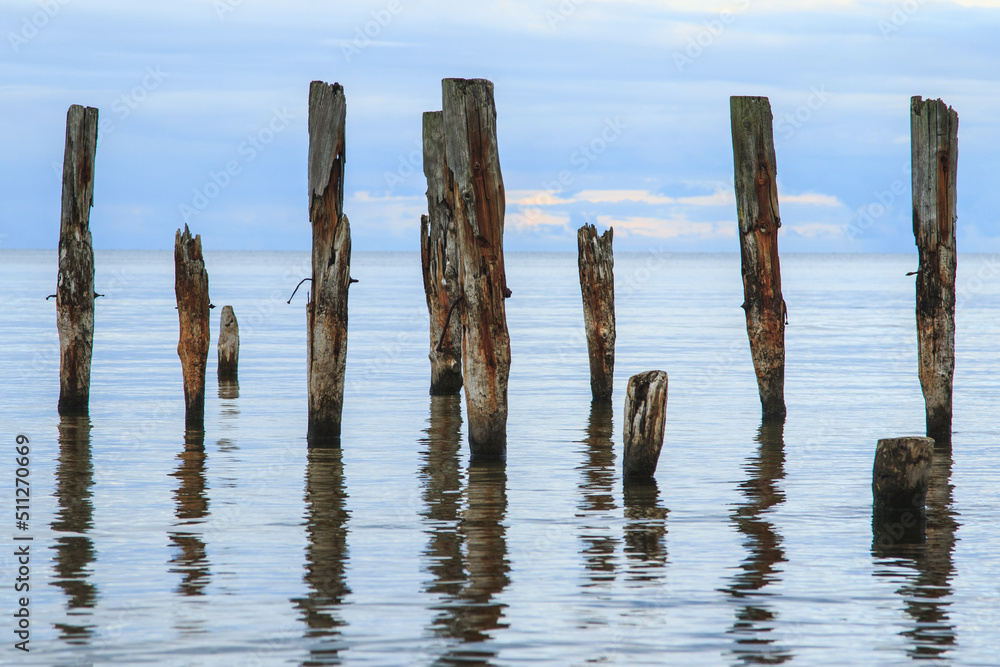 Sea scenery with broken pier poles sticking from water. Sea scenery with broken pier poles sticking from water.