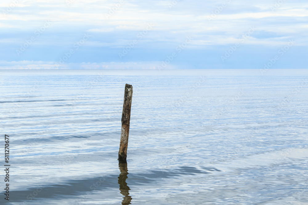 Fototapeta premium Sea scenery with broken pier pole sticking from water.