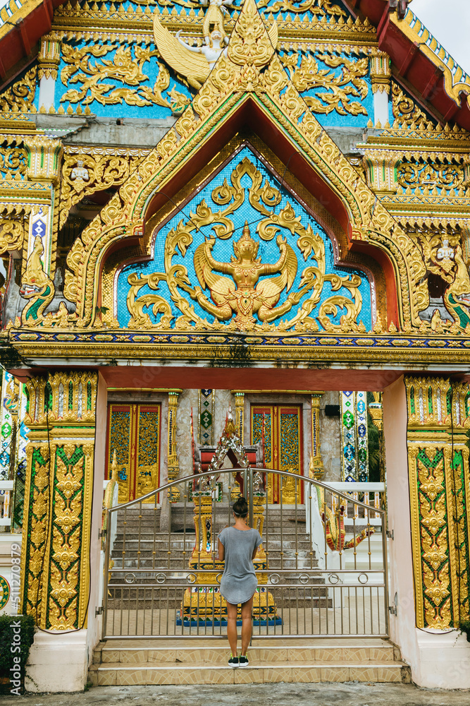 Young female tourist is sightseeing buddhist temple in Thailand.