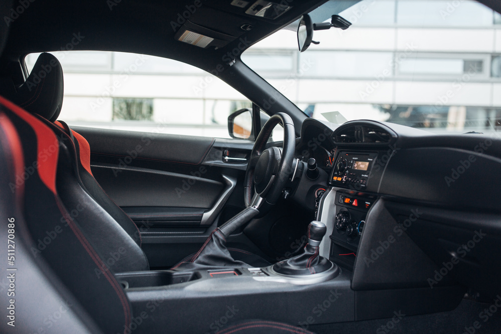 Modern supercar interior with the leather panel, sport seats, multimedia, and digital dashboard