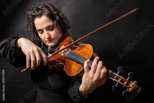 Beautiful girl professional violinist playing antique violin