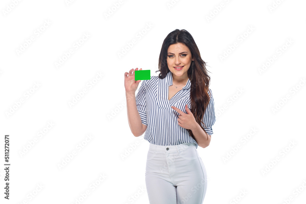 Beautiful brunnet сaucasian young girl in white pants and striped shirt holding bank or business card (saved with path) isolated on white background Beautiful brunnet сaucasian young girl in white pants and striped shirt holding bank or business card (saved with path) isolated on white background