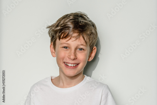 Laughing boy. Portrait of a white caucasian 9 year old boy in a white t-shirt. Copy space
