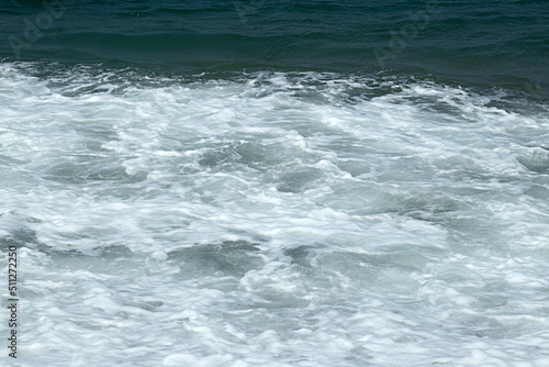 Natural wavy background of blue bubbling sea water.