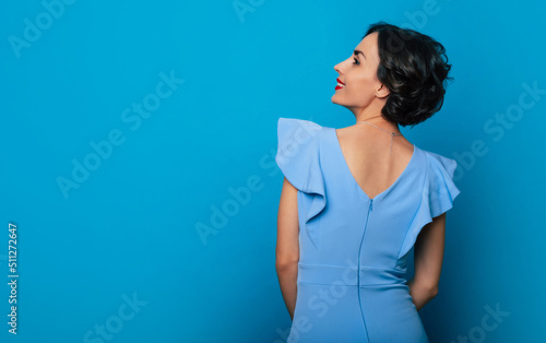 Fotografiet Back view photo of stylish elegant young beautiful woman with curly hairstyle in
