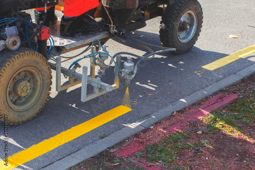 Road workers use hot-melt scribing machines to painting pedestrian crosswalk on asphalt road surface in the city.