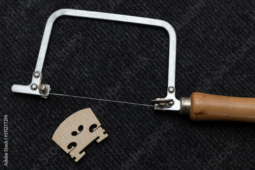 Fotografie Top view of a saw and a finished violin bridge