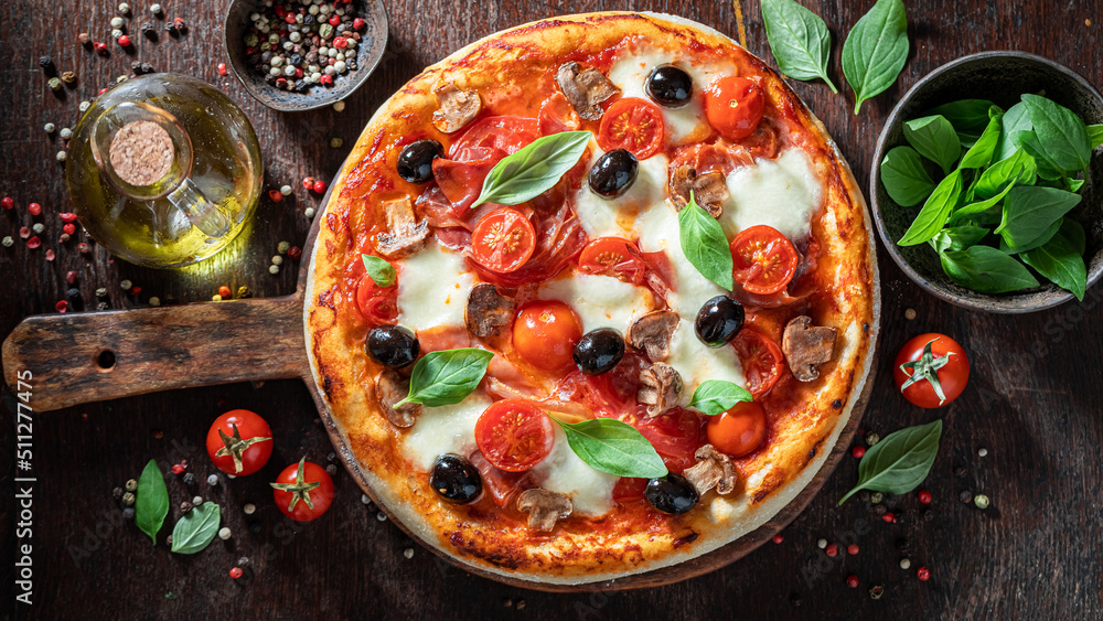 Tasty and healthy pizza Capricciosa with mozzarella, tomatoes and prosciutto.