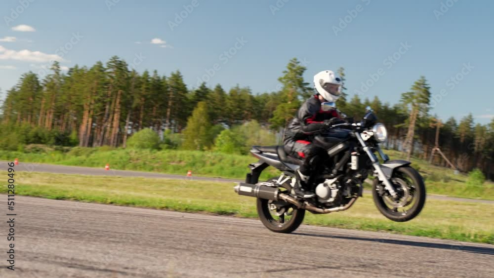 Revving up motorcycle with wheelie on racetrack at Latvia Revving up motorcycle with wheelie on racetrack at Latvia