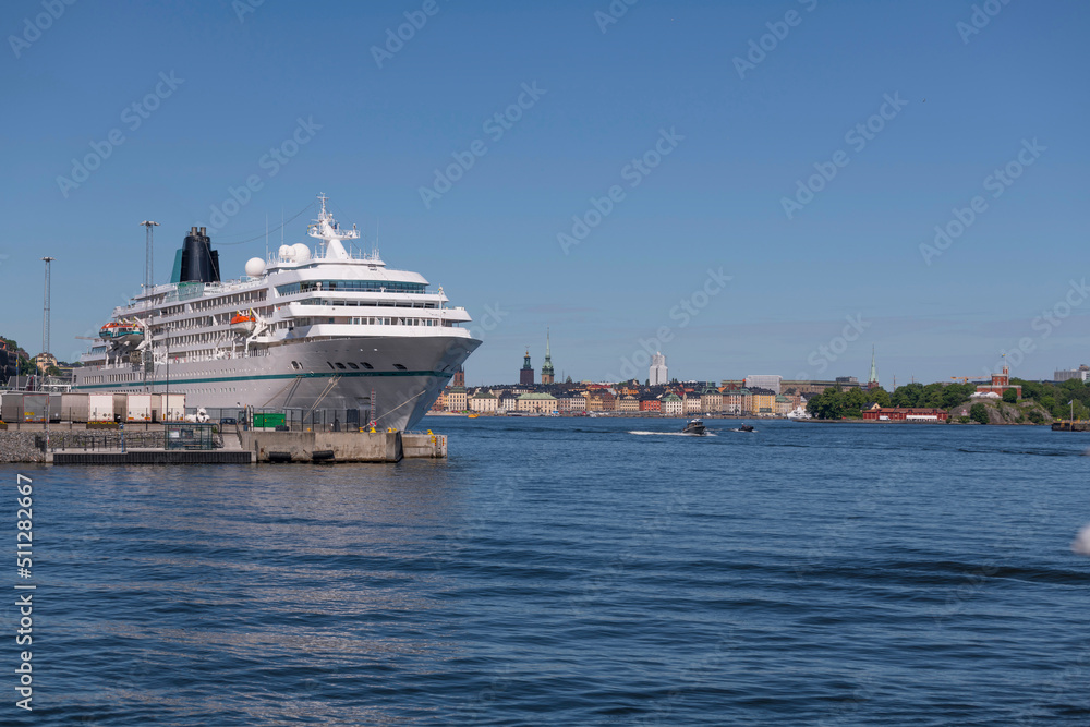 Tourist cruise ship at the pier Masthamnen and the skyline of the old town Gamla Stan a sunny summer day in Stockholm  