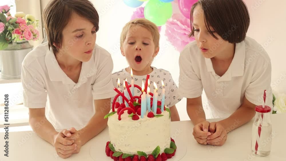 Cute child, preschool boy, celebrating birthday at home with homemade cake with raspberries, mint and candies, balloons and decoration in the room Cute child, preschool boy, celebrating birthday at home with homemade cake with raspberries, mint and candies, balloons and decoration in the room