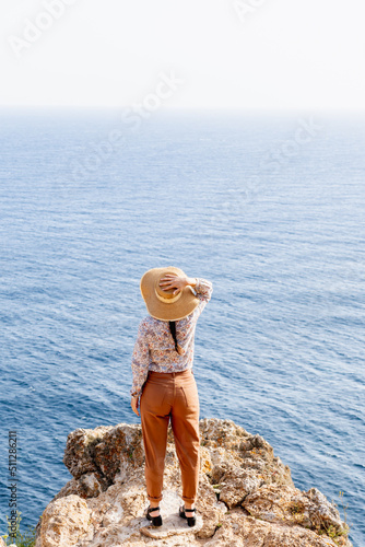young woman watching the sea from a cliff